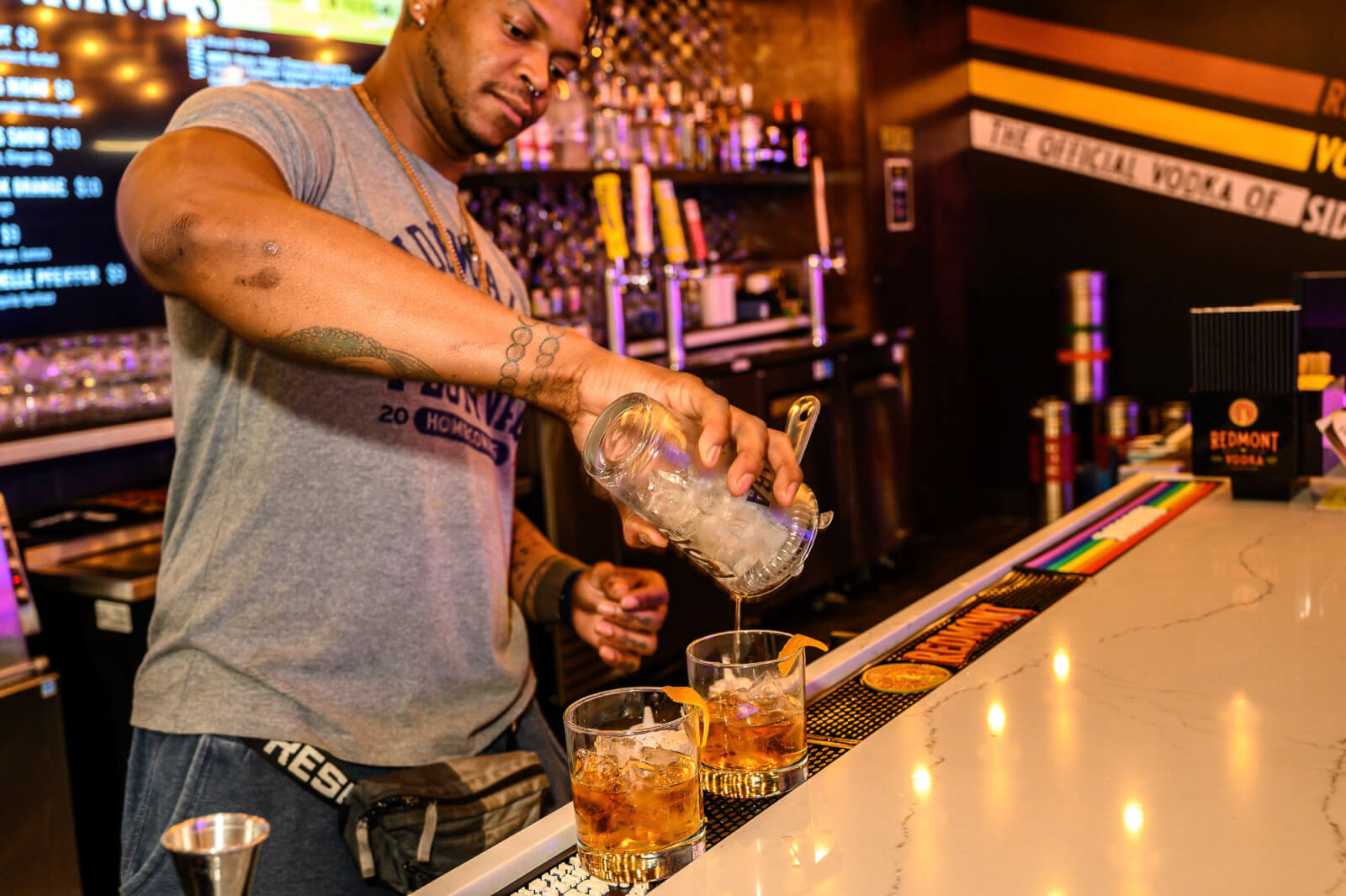 Bartender making two craft cocktails.