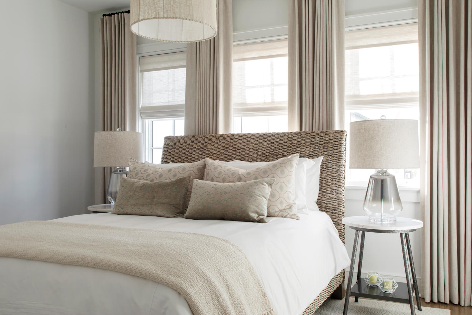 Three windows with light coming into a master bedroom.