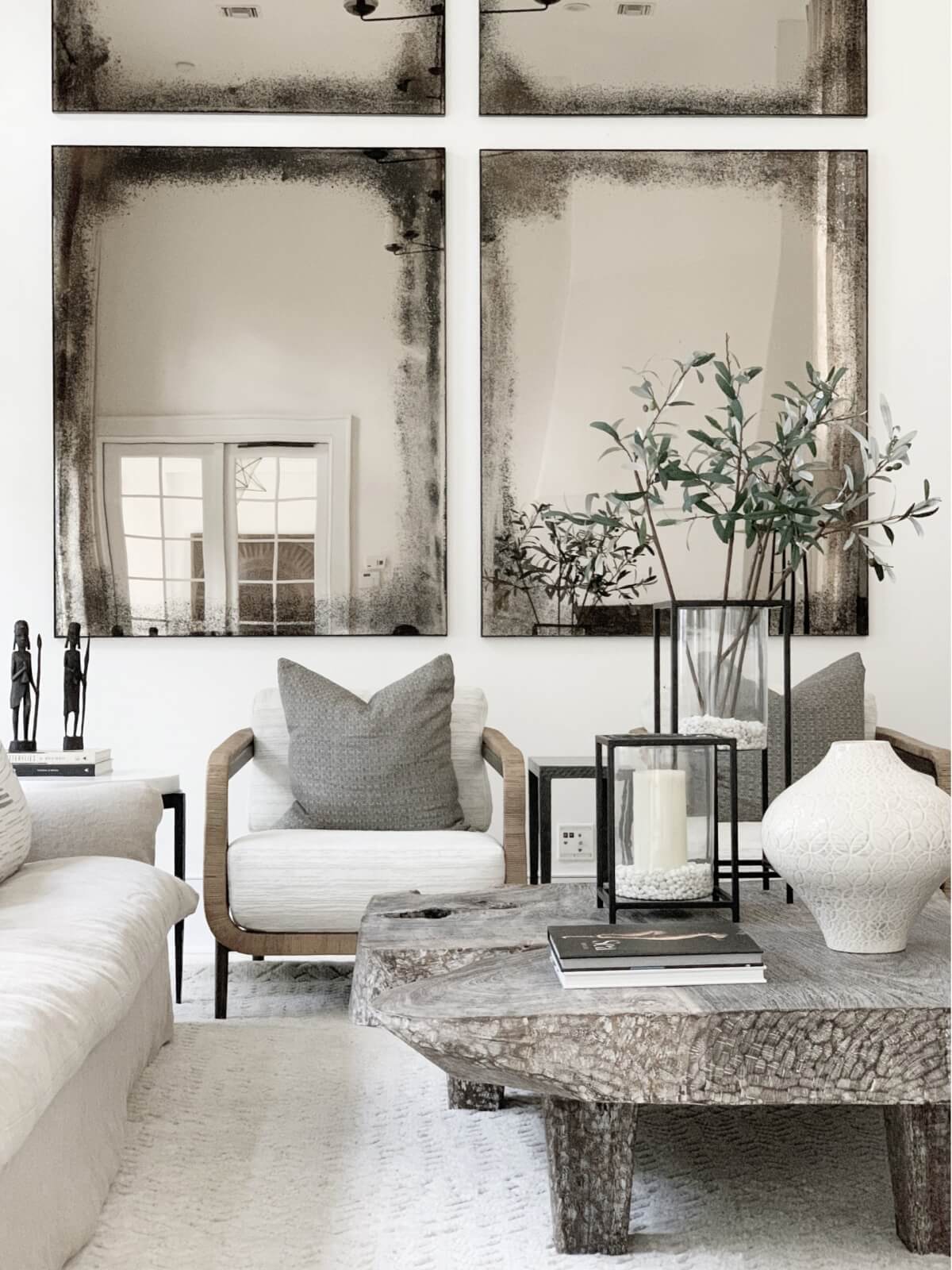 A quartet of mirrors in a white-themed sitting room