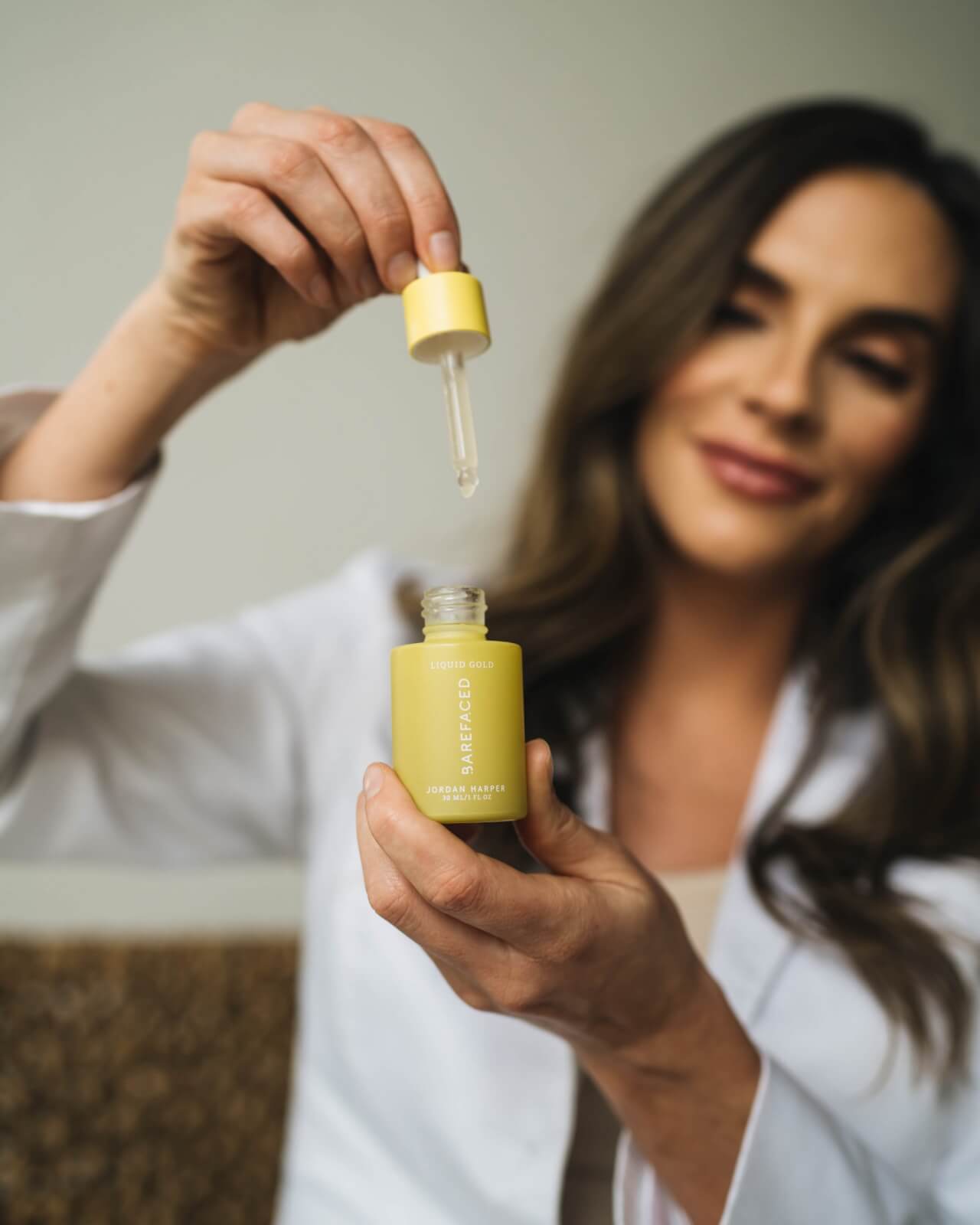 woman demonstrating serum skincare product dropper