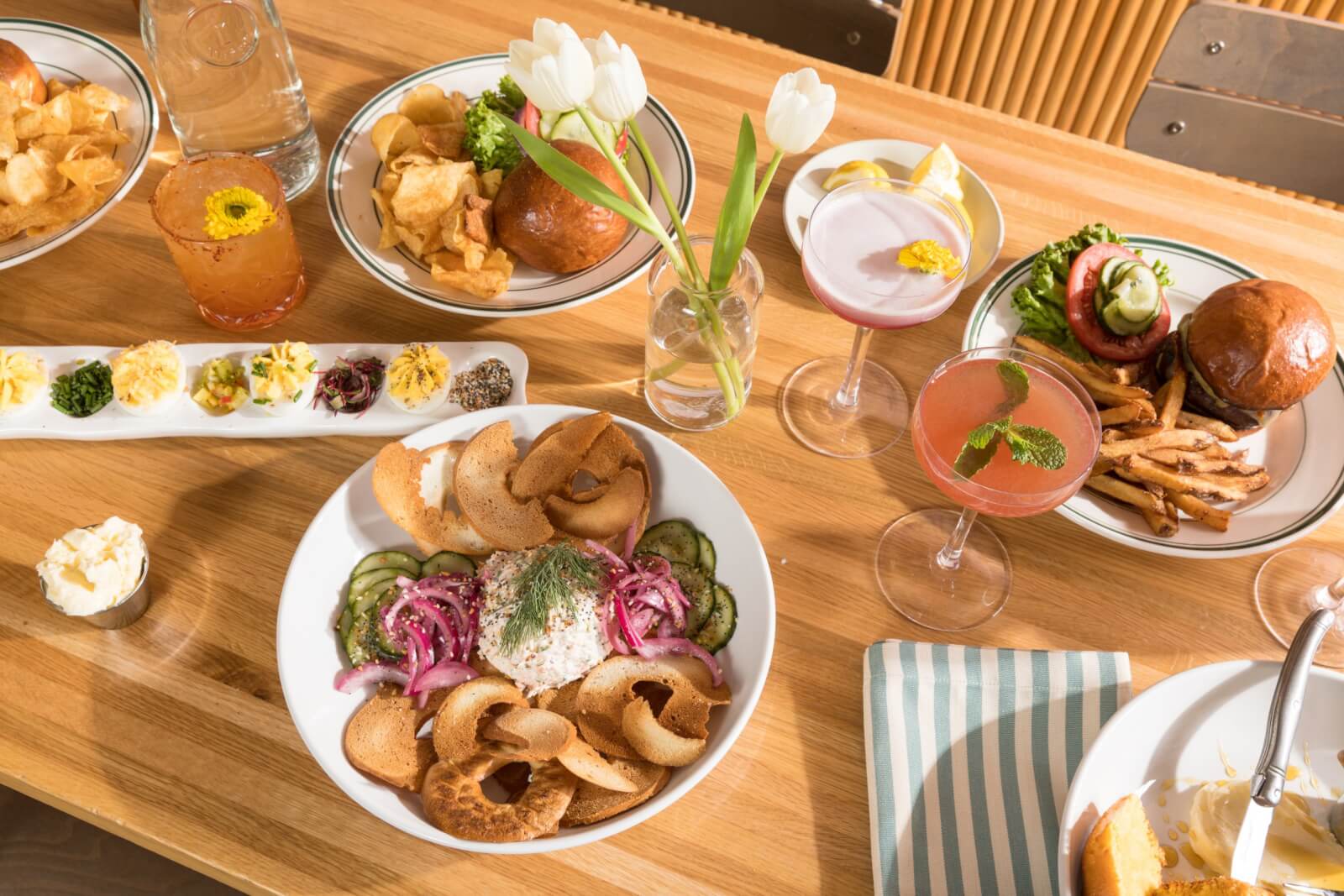 full table set with menu items including deviled eggs and a burger