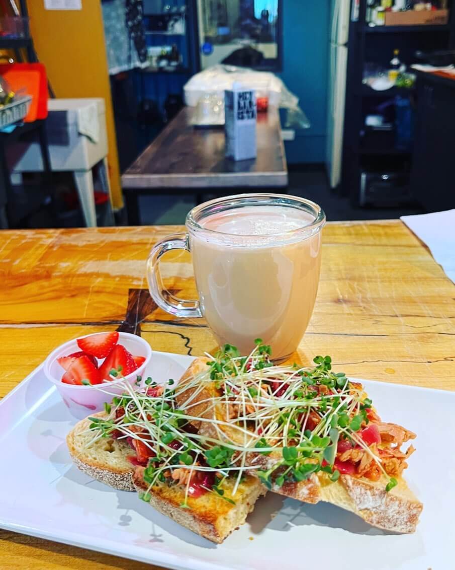 Tuna on toast and coffee drink on table.