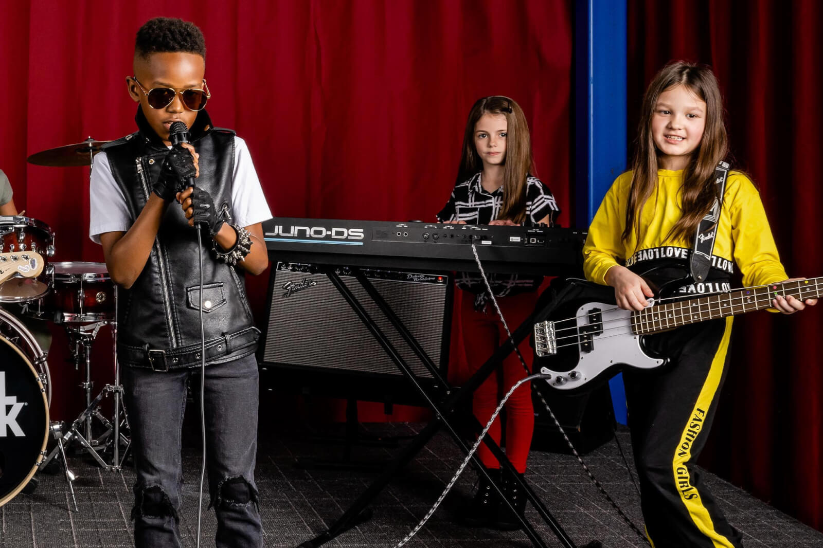 three children playing rock music instruments