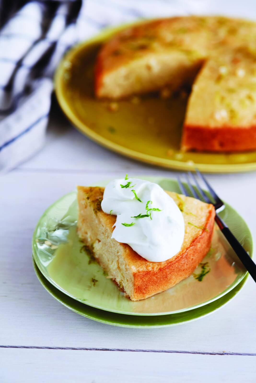 Slice of piña colada cake, topped with with frosting.