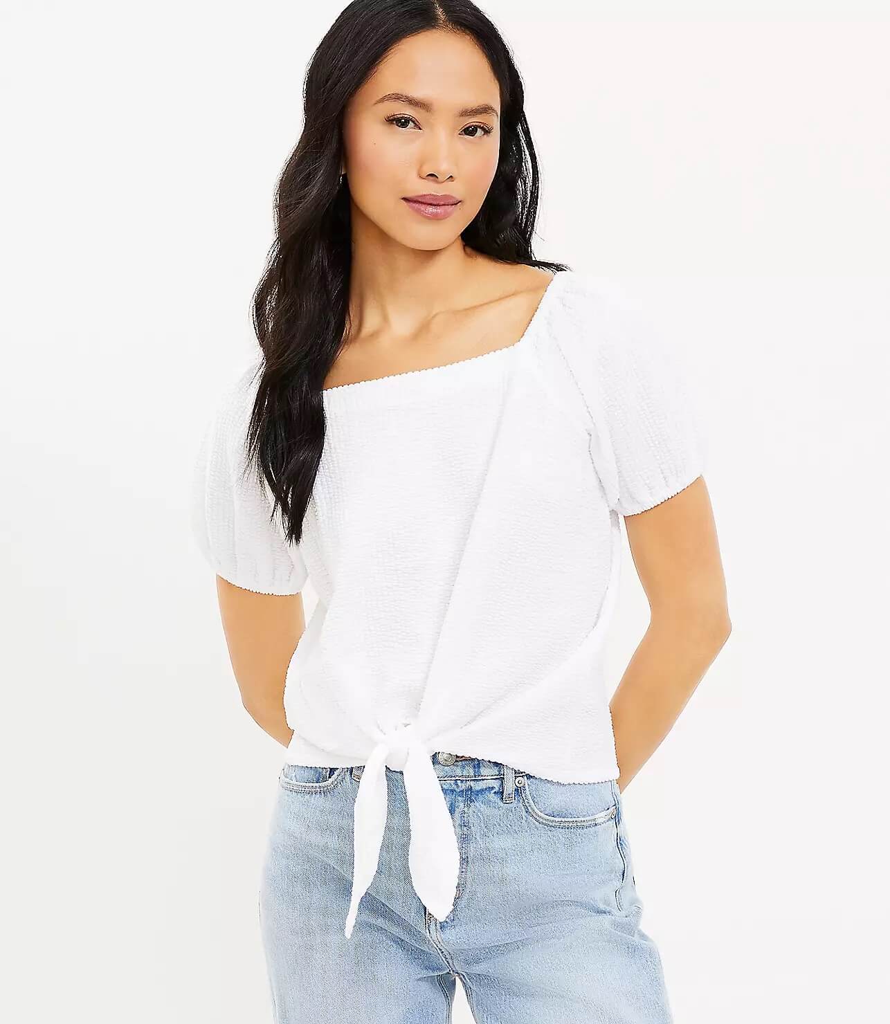 Model wearing white seersucker crop top that ties in the front.