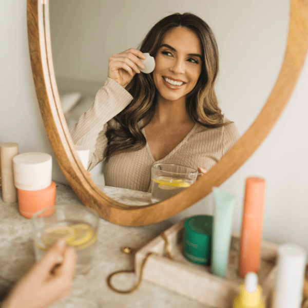 woman applying skincare in mirror