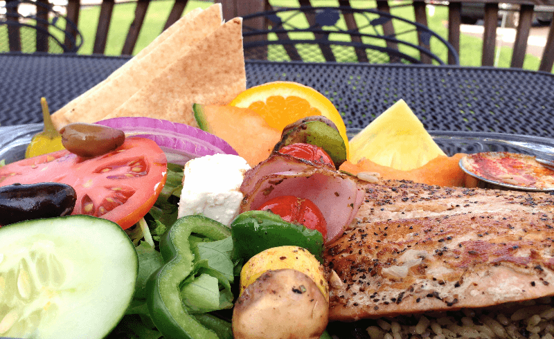 Platter of chicken and vegetables with pita points.